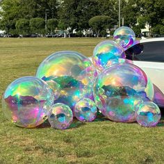 soap bubbles are piled on the ground next to a car