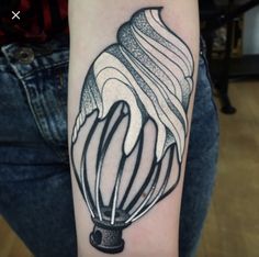 a woman's arm with an ice cream cone tattoo on it