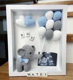 an elephant is holding balloons in a shadow box with the word boy written on it