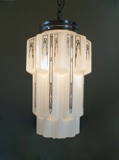 an art deco chandelier hanging from a ceiling in a room with black walls