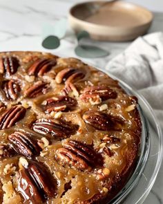 a cake with pecans on top sitting on a plate