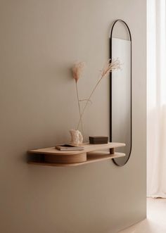 a mirror and shelf in a white room