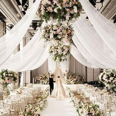 a bride and groom are standing under a floral covered arch at the end of their wedding ceremony