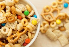 a bowl filled with cereal and pretzels on top of a table