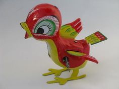 a red bird figurine with green eyes on it's head and legs