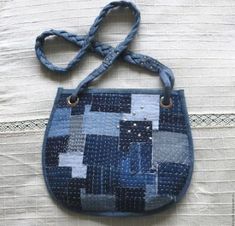 a blue purse is sitting on a white tablecloth with a knot in it's handle