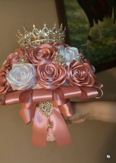 a bridal bouquet with pink and white flowers on it is being held by someone's hand