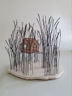 a sculpture made out of sticks with a house in the middle