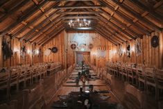 the inside of a wooden building with tables and chairs set up for a formal function