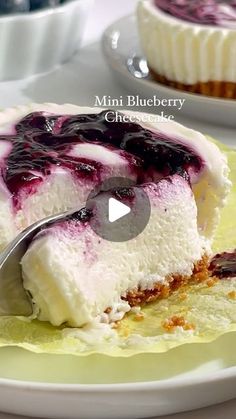 a piece of cheesecake with blueberry sauce on it and a fork in the middle