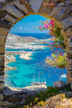 the view from an arch looking out at boats in the water