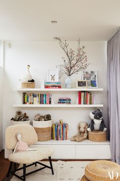 a white shelf with books and stuffed animals on it