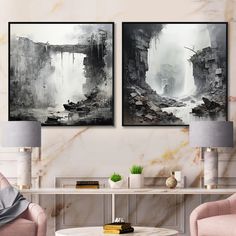 two black and white paintings hanging on the wall above a coffee table with pink chairs