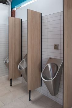 three metal urinals in a public restroom