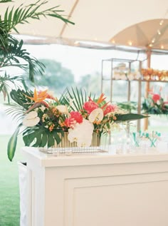 an outdoor bar with flowers and greenery on it