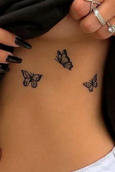 a woman's stomach with three butterflies on her side and the word love written in black ink