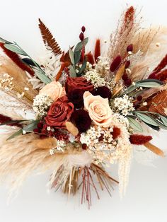 an arrangement of flowers and feathers on a white background