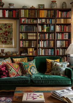 a living room filled with lots of books on top of a book shelf next to a green couch