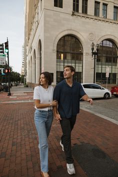 a man and woman are walking down the street