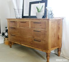 a wooden dresser sitting next to a window