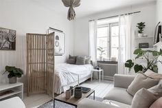 a living room with white walls and furniture in the corner, including a couch, coffee table