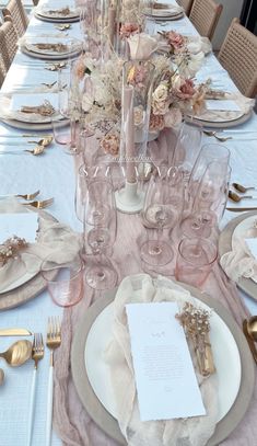 the table is set with white and gold place settings