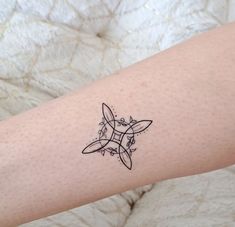 a small tattoo on the arm of a woman's left arm, with an abstract design