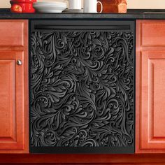 a black door mat with an intricate design on it in front of wooden cabinets and cupboards