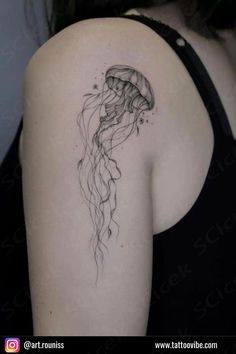 a woman's back shoulder with a jellyfish tattoo on the left side of her arm