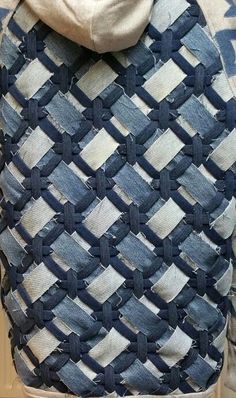 the back of a woman's jacket with blue and white weaves on it