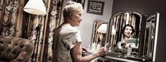 an older woman sitting in front of a mirror