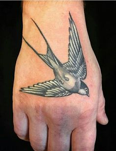 a hand with a bird tattoo on it