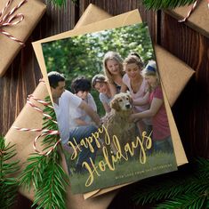 a holiday card with an image of family and dog on it, surrounded by presents