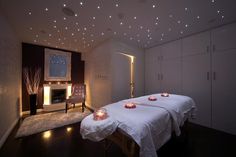 two beds in a room with lights on the ceiling