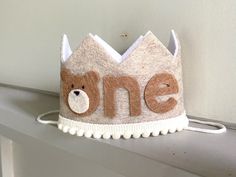 a felt crown with the word one written on it