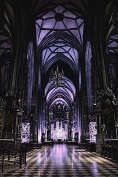 the inside of a large cathedral with chandeliers and checkered tile flooring