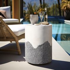 a table that has some bottles and glasses on it next to a chair near a pool