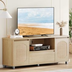 a flat screen tv sitting on top of a wooden entertainment center next to a lamp