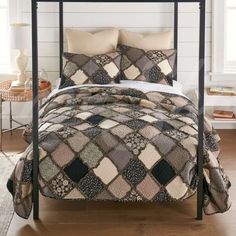 a bed with two pillows on top of it and a blanket over the headboard