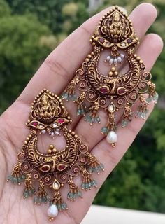 two pairs of gold colored earrings with pearls and beads on the ends of each ear