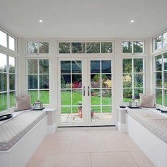 a sun room with three windows and two benches