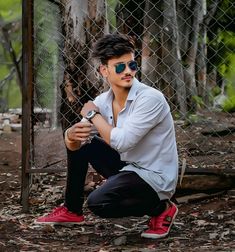 a man sitting on the ground wearing sunglasses