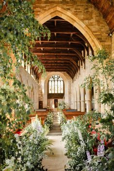 the inside of an old church with flowers and greenery