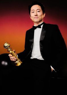 a man in a tuxedo holding an award for best performance at the oscars