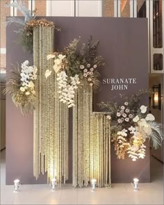 a display with flowers and candles in front of a sign that says sufranate john