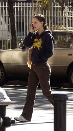 a woman walking down the street talking on her cell phone