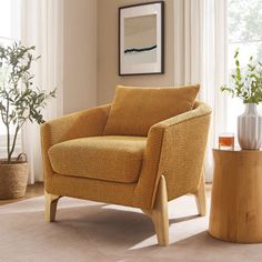 a living room with a yellow chair and potted plants on the floor next to a window