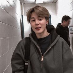 a young man is standing in the hallway