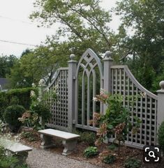 a white bench sitting in front of a garden gate