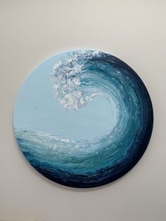 a painting of a wave in the ocean on a white wall with blue and green colors